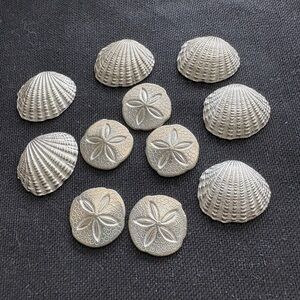 11 silver tone shell pocket tokens in bag.